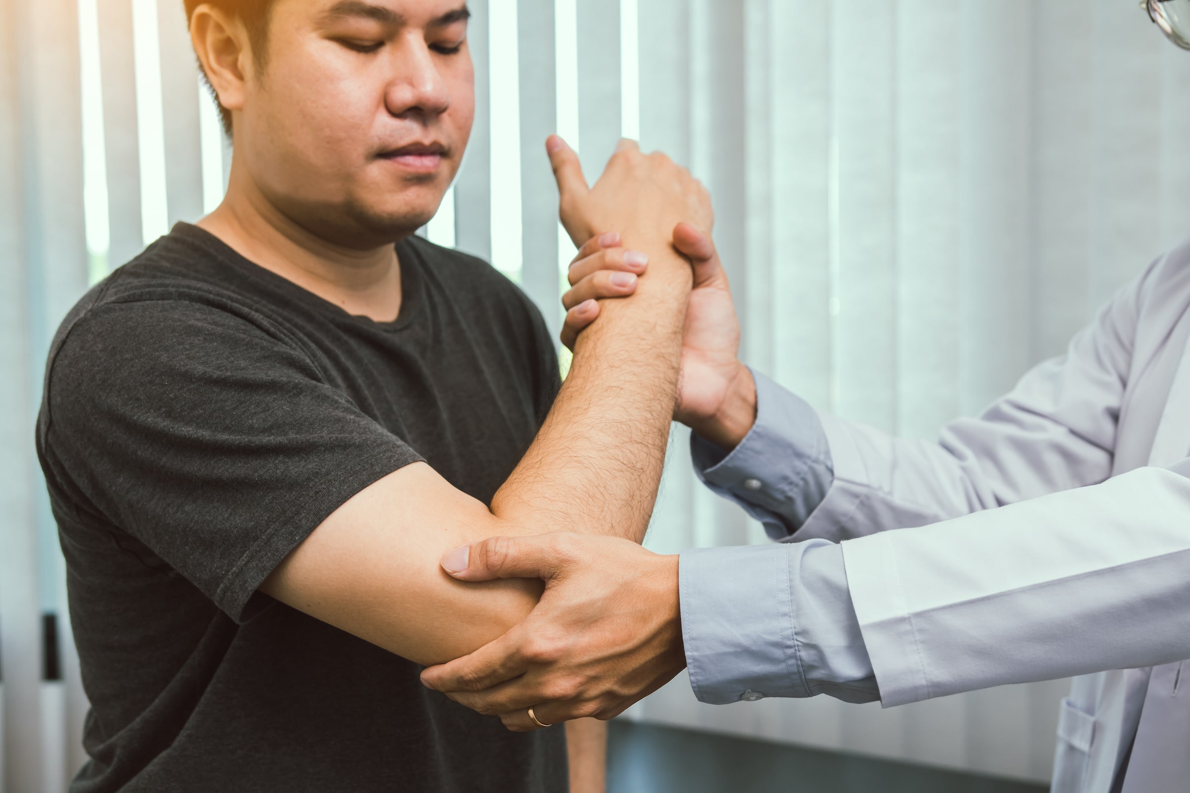 physiotherapist checking elbow of a patient
